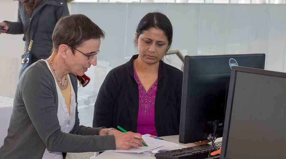 Two students do research at a library computer